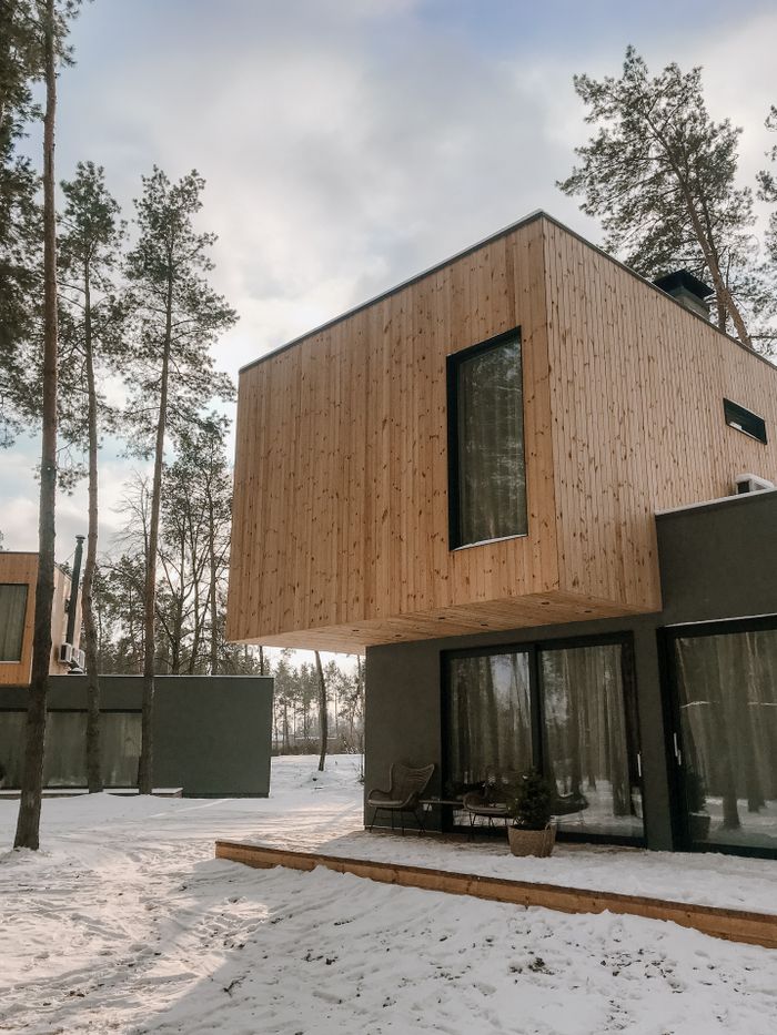 Contemporary wooden house surrounded by snowy landscape in a Scandinavian style.